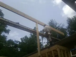 Carpenter setting a ridge beam over a new addition frame — Ice Dam Removal by Roofing Brothers in Irwin